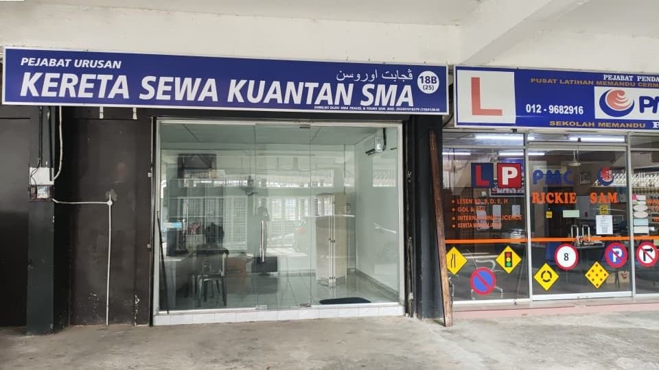 Hadapan pejabat SMA Car Rental di Stadium Darul Makmur, Kuantan, dengan papan tanda biru Kereta Sewa Kuantan SMA di lot 18B